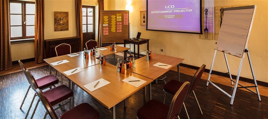 Tagungsraum mit Beamer, Leinwand und individueller Bestuhlung